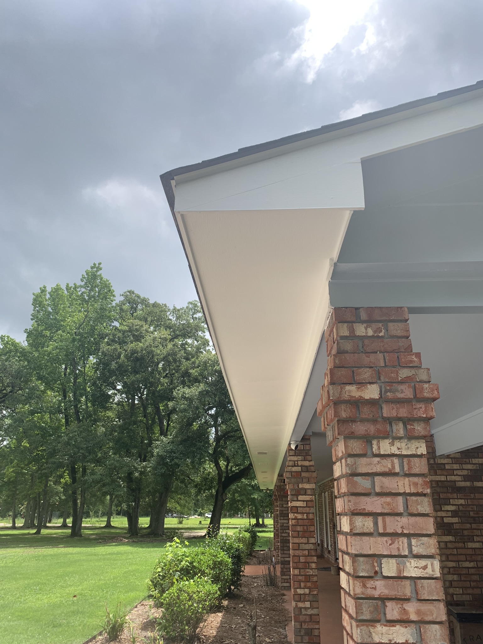 Painting in Picayune MS - Paint Star - white soffit on house freshly painted, pretty, cloudy